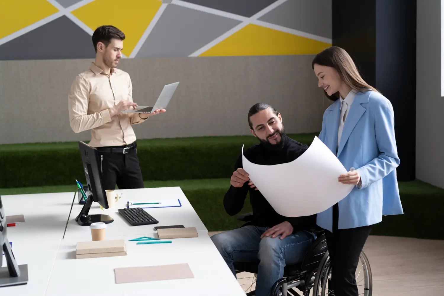Wheelchair user reviewing documents with colleagues in a collaborative office setting