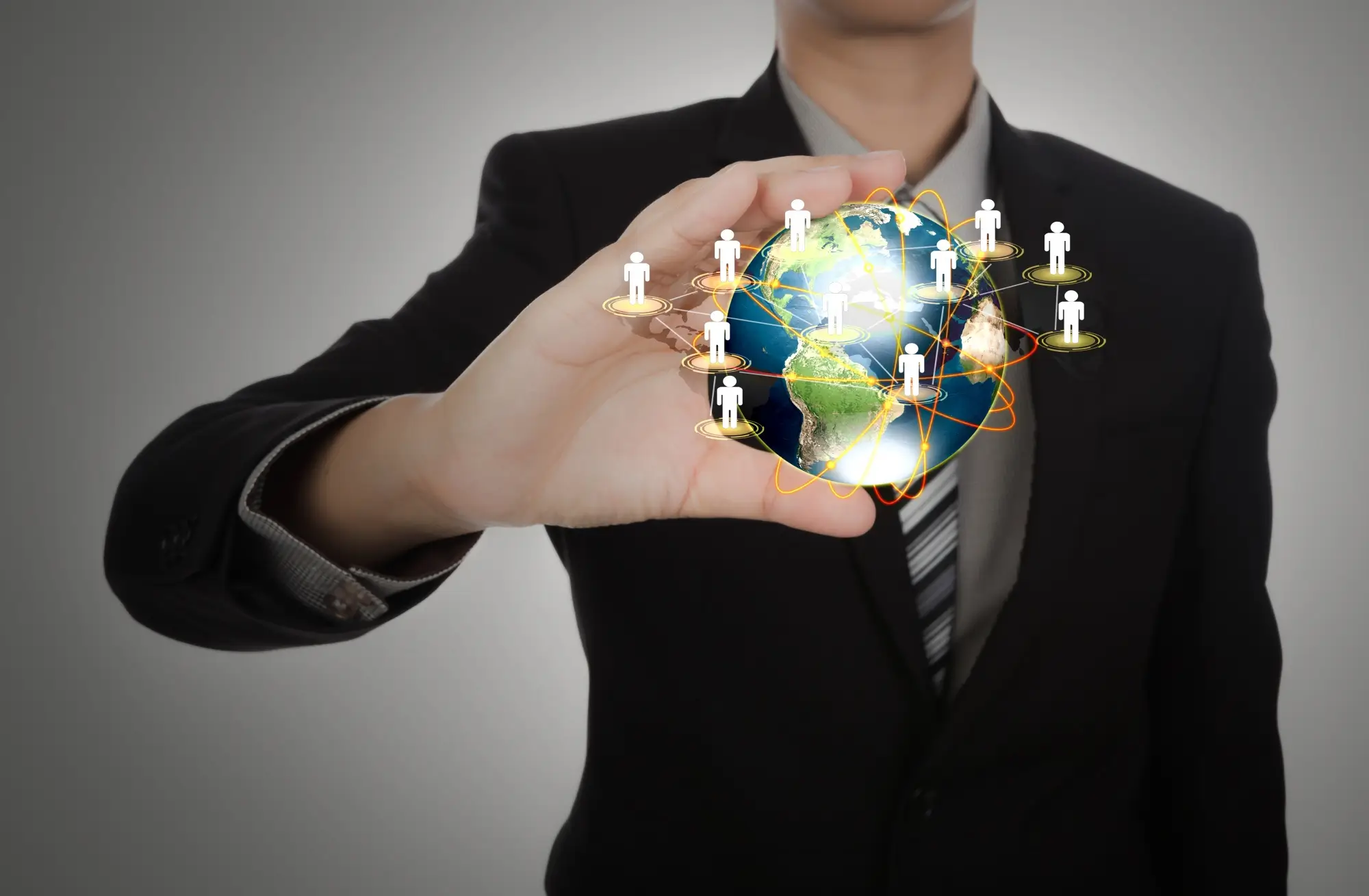 Business professional holding a digital globe with global connection icons