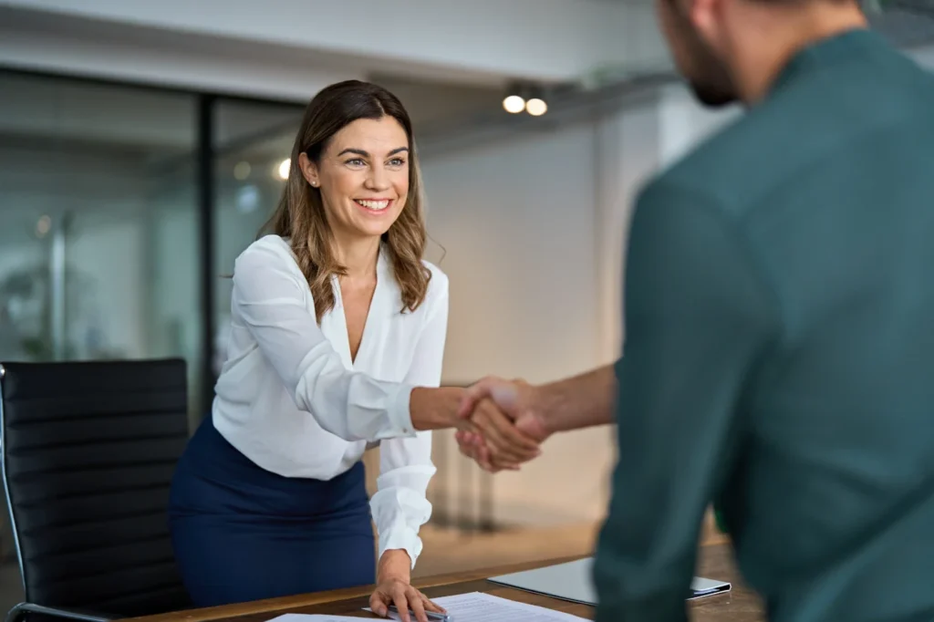Professional woman shaking hands with a client during a business meeting