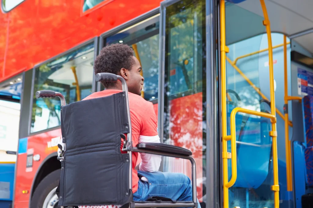 Wheelchair user boarding an accessible public bus with open doors