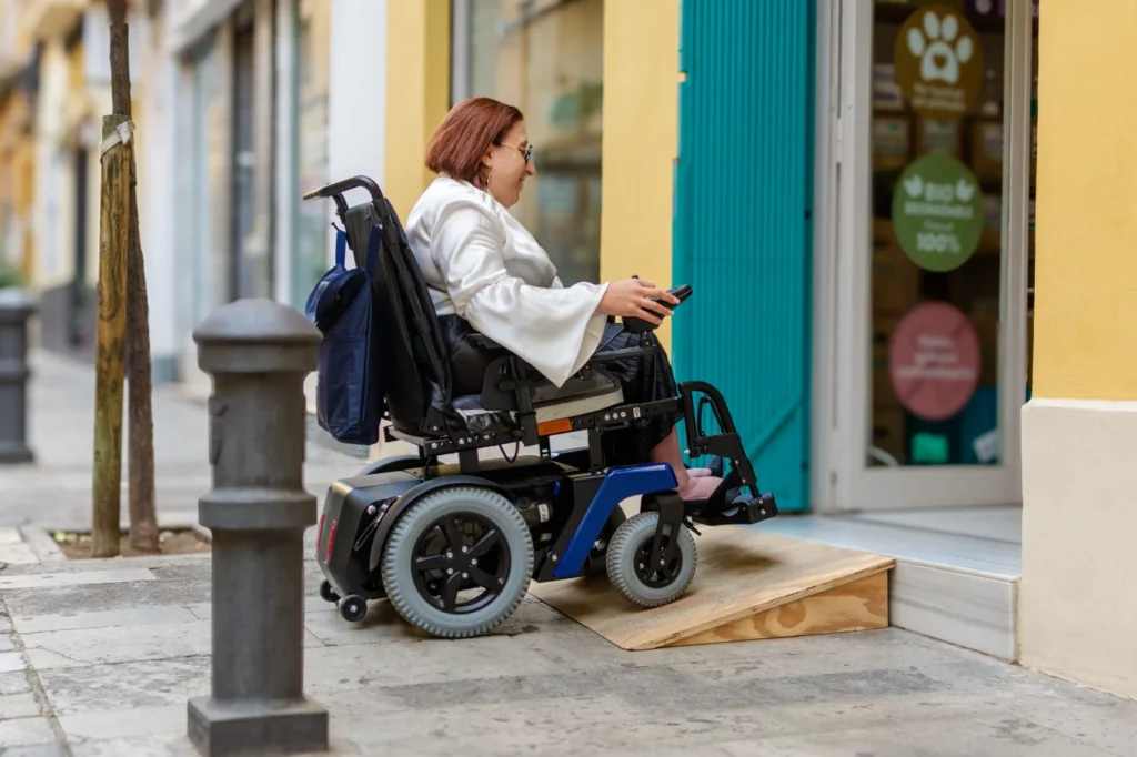 Wheelchair user entering a shop using a temporary accessibility ramp