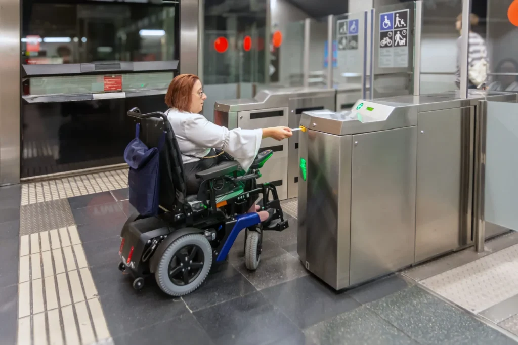 Wheelchair user passing through an accessible ticket gate at a train station