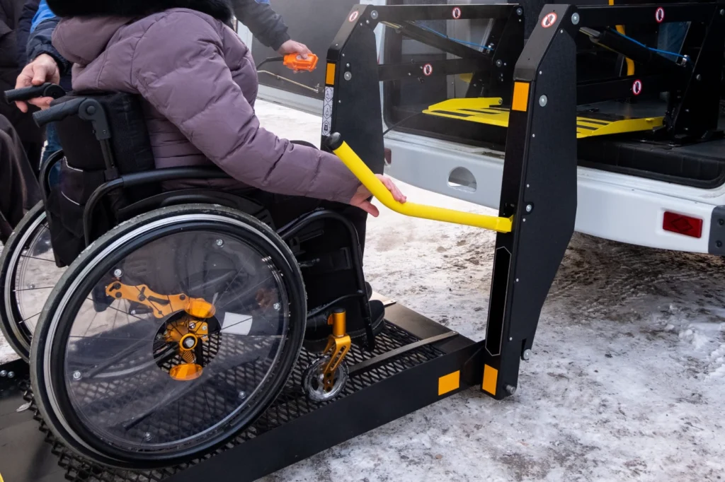Wheelchair user using an accessible vehicle lift for public transportation.